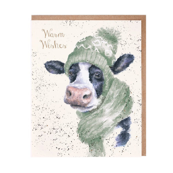 A Christmas greeting card that features a cow wearing winter clothes
