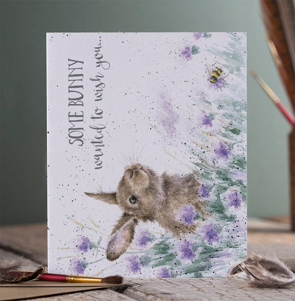 A birthday greeting card with a bunny among the flowers