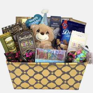 Calgary birthday gift basket that has a "Happy Birthday" teddy with gourmet snacks, chocolates organized beautifully in a golden blue rectangular basket.