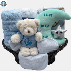 Calgary baby gift basket filled with baby clothes, cute plush toys, blanket and a 5 piece baby suit arranged neatly in a brown pedestal basket.