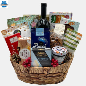Made in Calgary Holiday gift basket with large number of delicious gourmet snacks & award winning wine packed in a large hyacinth oval basket.