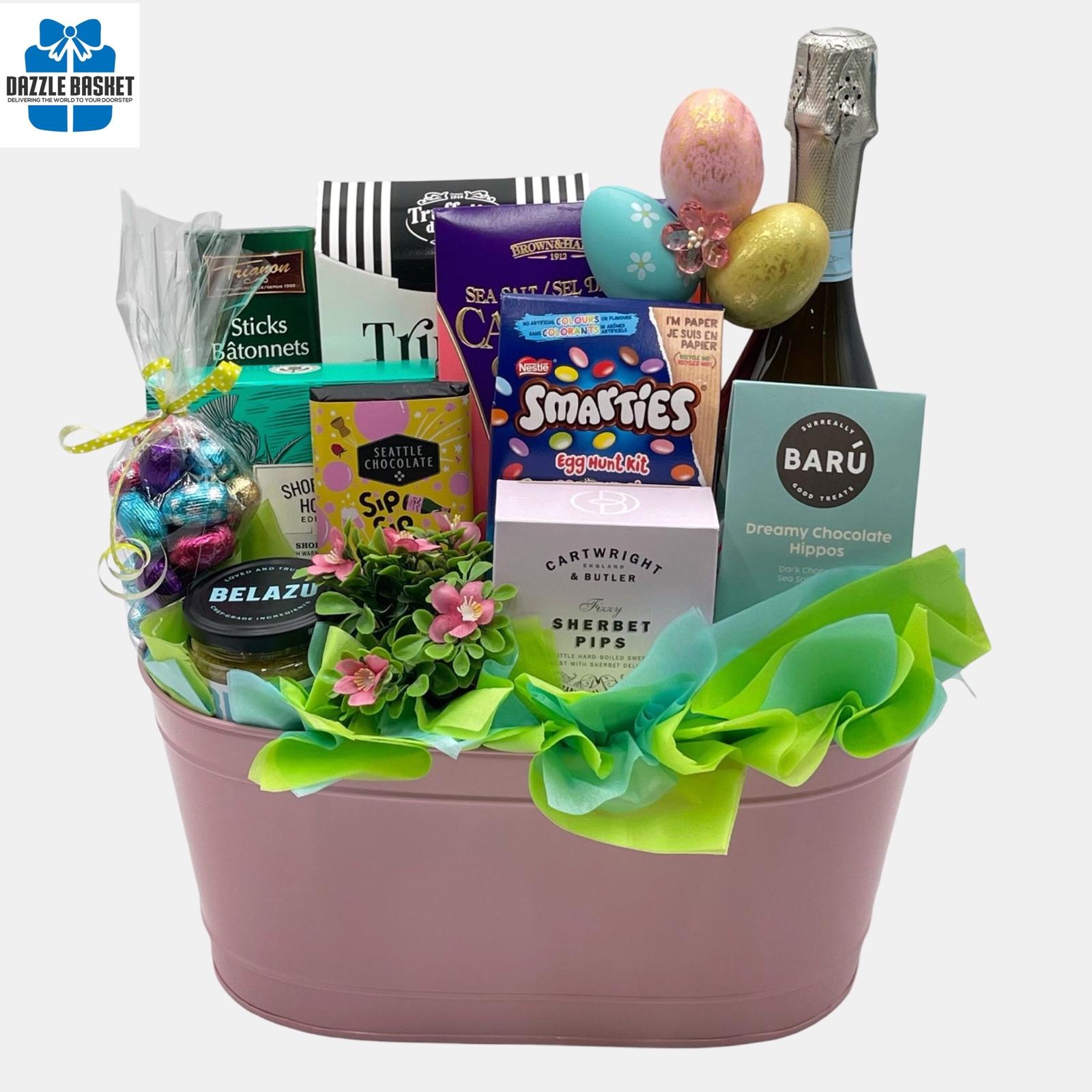 A Calgary Easter gift basket for the entire family  with Easter themed chocolates and gourmet snacks and a bottle of Prosecco arranged creatively in a beautiful pink metal container.
