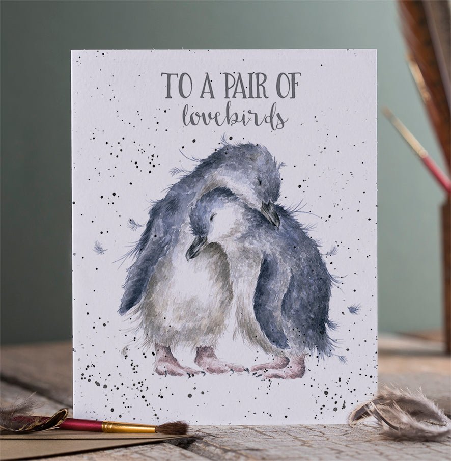 An Anniversary greeting card that has a picture of two penguins cuddling.