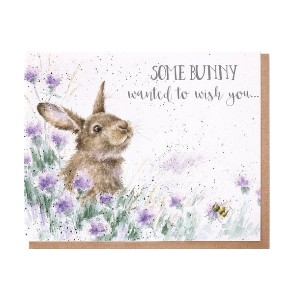 A birthday greeting card with a bunny among the flowers