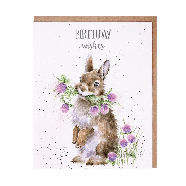 A birthday greeting card with picture of a bunny holding bunch of purple wildflowers.