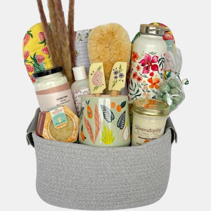 A made in Calgary housewarming gift basket that includes delicious gourmet sweets and number of household and spa items arranged neatly in a reusable cotton basket.
