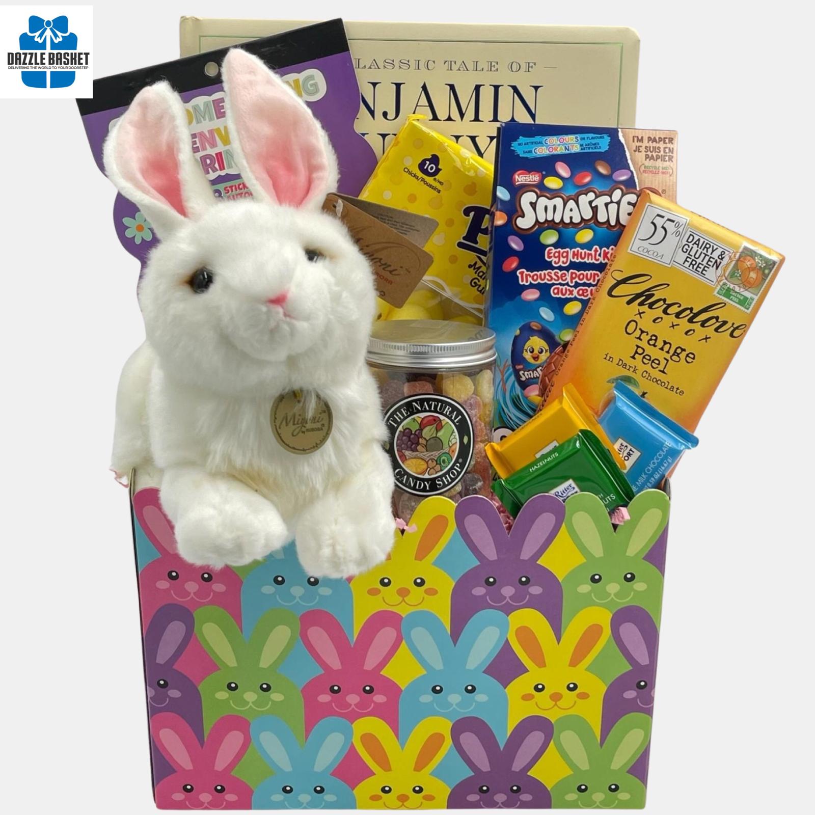 A Calgary Easter gift basket with Easter bunny plush toy and themed chocolates and gourmet snacks arranged beautifully in a bunny themed box.