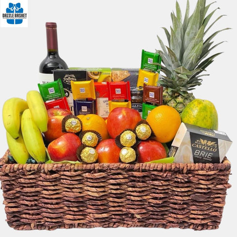 A made in Calgary fruit gift basket that includes fresh fruits, a bottle of wine, chocolates, crackers, cheese and shortbread cookies arranged neatly in a rectangular basket.