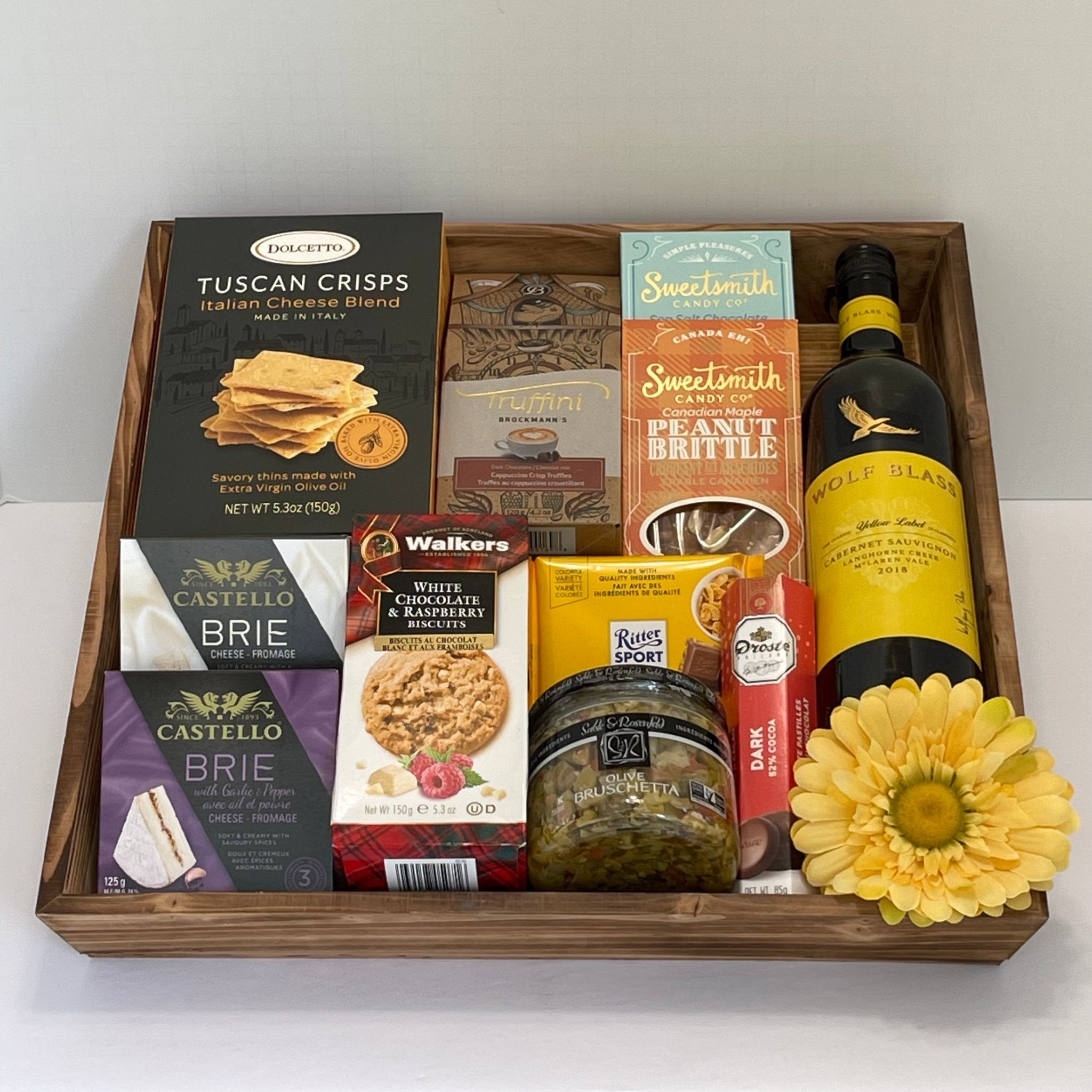A made in Calgary gift basket made in a large wooden tray and includes a bottle of wine and tasty gourmet snacks to celebrate an occasion such as anniversary, birthday, housewarming.