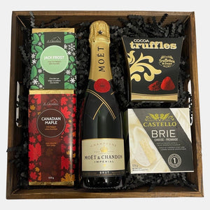 A champagne gift basket that includes a bottle of Moet & Chandon champagne, handmade Belgian chocolates and cheese