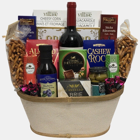 A made in Caqlgary gift basket that includes an award winning red wine, delicious gourmet snacks organized neatly in a cream golden container. It is one of our most popular basket.