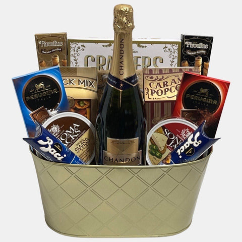 A made in Calgary gift basket that has an assortment of delicious gourmet snacks along with a bottle of Chandon Imperial Brute (750ml) bottle arranged creatively in a golden metal container